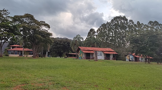 Vista ampla do terreno da pousada com chalés entre as árvores
